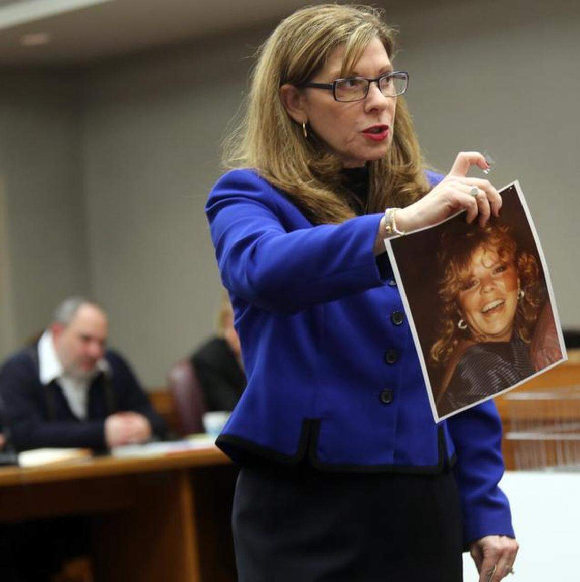 FILE - Prosecutor Gail Levine, holds up a photo of murder victim, Linda Azcarreta, 32, stabbed to death by Rafael Andres (pictured in the background) in 1987. Andres later went on to murder Yvette Fariñas in 2005 and is currently in the death penalty phase of his trial.