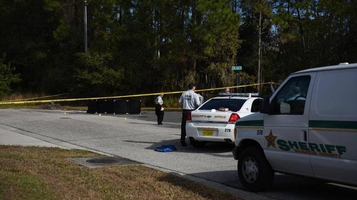 Investigators confer Wednesday at the site where a body was found in the back of an industrial park.