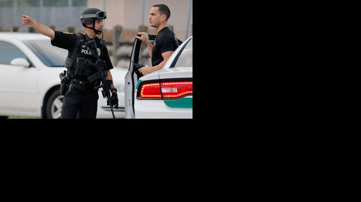 
MULTIAGENCY OPERATION: Miami Gardens and Miami-Dade police officers work the scene of the shooting at Northwest 33rd Court and 187th Street in Miami Gardens on Thursday. 
