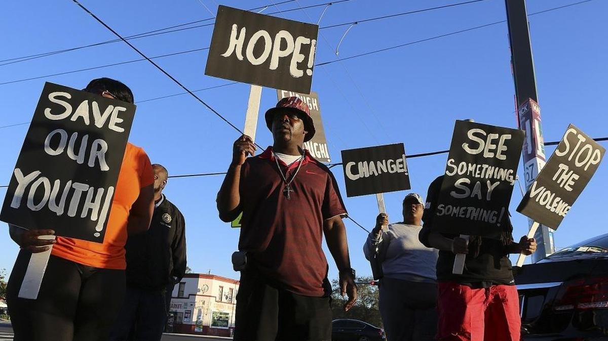 Willie Rembert, center, grandfather of 6-year-old King Carter, holds a sign with other family members and supporters during a rally for King on Thursday, Feb. 25, 2016. King was shot and killed Saturday during a drive-by shooting outside his apartment at Blue Lake Village, at Northwest 103rd Lane and 12th Avenue in Miami-Dade. The rally started nearby, at Northwest 103rd Street and 12th Avenue, with a march and concluded at the complex.