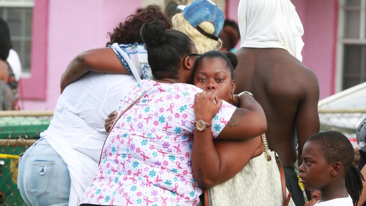 Mourners gather outside a Lauderhill home on Monday after three bodies were found inside. Police have not released any details about the circumstances.