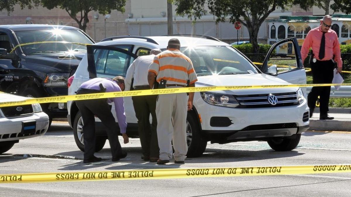 Miami-Dade police detectives looks for evidence near the VW SUV that was stolen from a nearby dealership. The suspect allegedley had a machete when he was shot by police after failing to comply to police commands to exit the vehicle at the corner of NW 57th Avenue and 183rd Street on Monday October 17, 2016