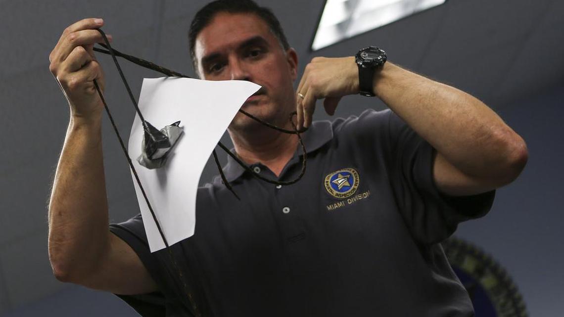 U.S. Postal Inspector Reldys Torres demonstrates how criminals used makeshift tools to fish out mail after a press conference on Thursday, Jan. 12, 2017 at the Miami Division Headquarters in Miramar. The U.S. Postal Inspection Service, Coral Springs Police Department, Miami-Dade Police Department and the Florida Attorney General's Office collaborated to execute "Operation Hook, Line and Sinker," an arrest round-up of nine targets who committed mail theft through a mail "fishing" technique.