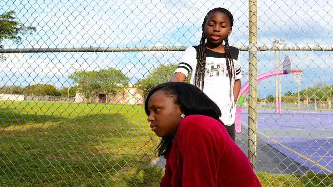 Wilniyah Jenkins, 13, seating, hangs out with her cousin Connie, 11, outside a basketball court down the street from Charles R. Drew Middle School on Friday, March 4, in Liberty City. They were there to watch Wilniyah’s brother, William Jenkins, 15, play basketball with friends.