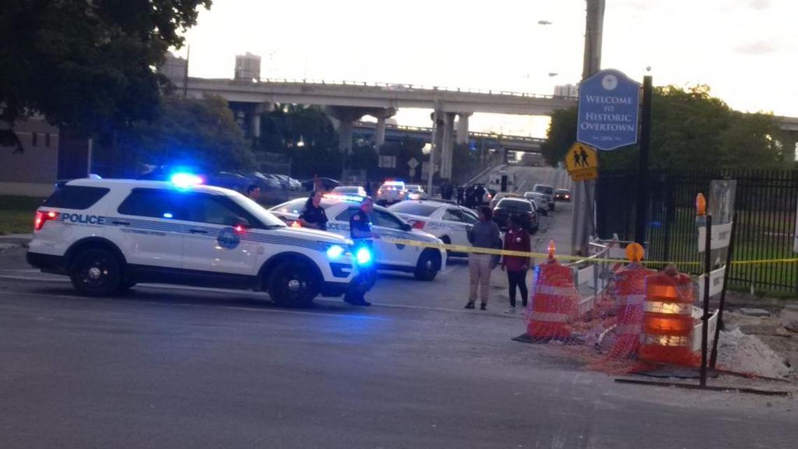 Miami police block off a shooting scene at Northwest 14th Street and Seventh Avenue, where a body is in the middle of the street.