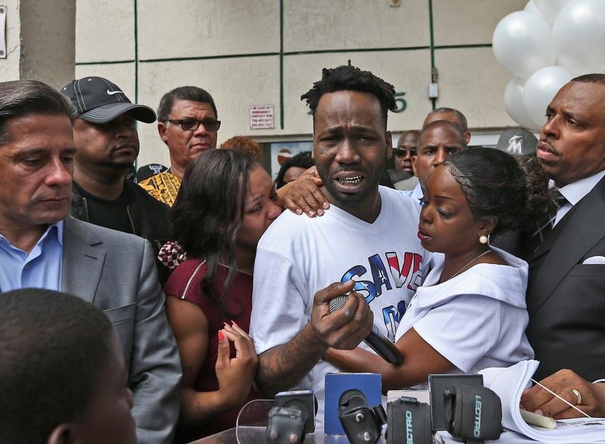 Santonio Carter breaks down while talking about the shooting death of his 6 year-old son King Carter. Community activist Tangela Sears, right, gives him support.
