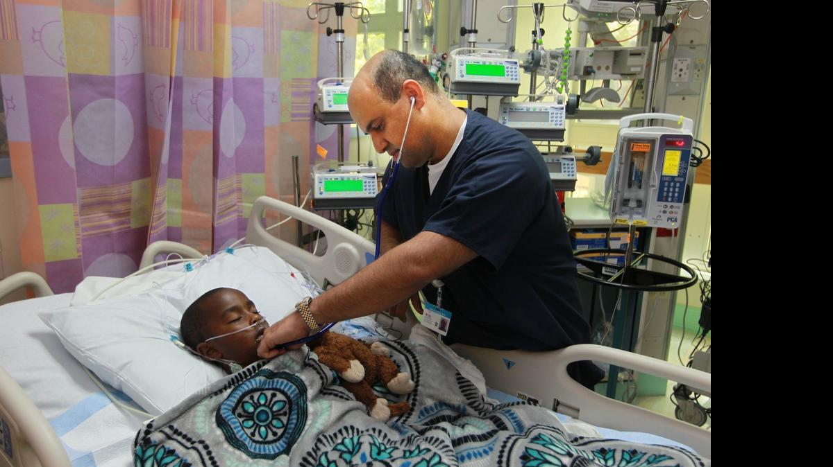 
Dr. Danyal Khan, a pediatric cardiologist at Nicklaus Children’s Hospital, looks at Deandre O' Connor on June 16, 2015. Khan is a medical professional who is balancing his religious life with his professional life during Ramadan, the Islamic holy month in which Muslims fast from dawn to dusk and pray at least five times a day.
