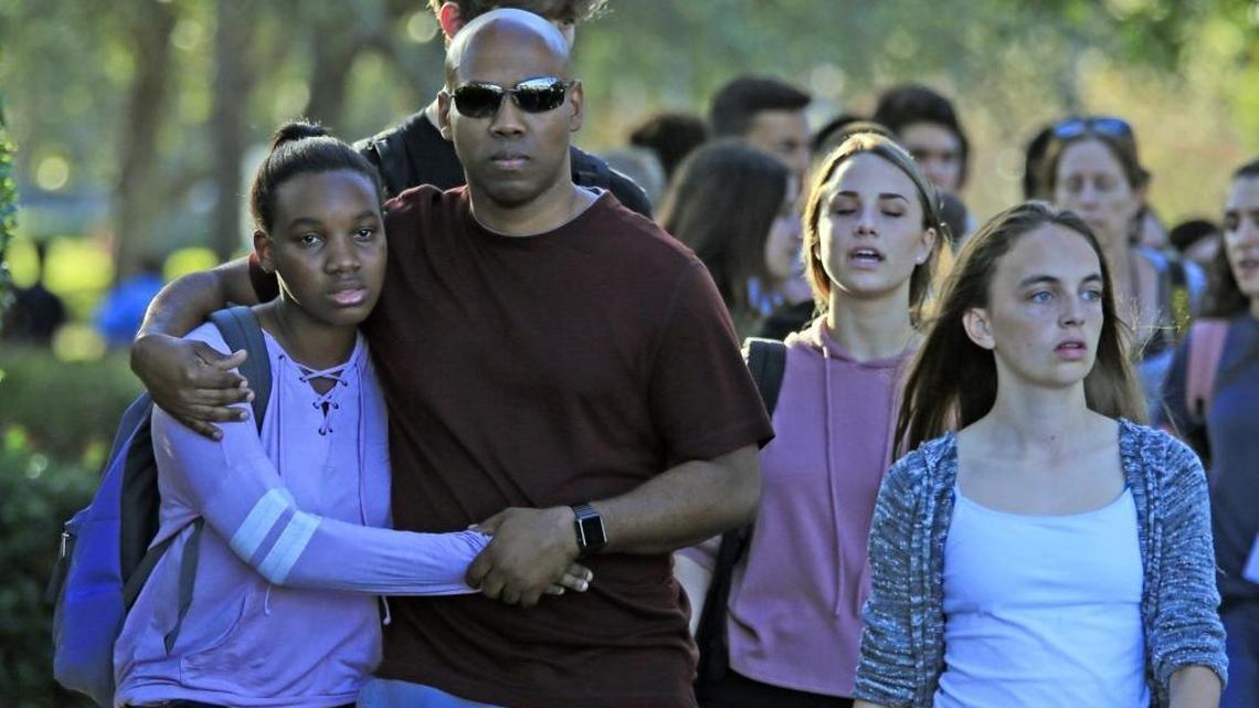 Students and parents leave campus after a gunman opened fire at Marjory Stoneman Douglas High School on Tuesday, Feb. 13, 2018.