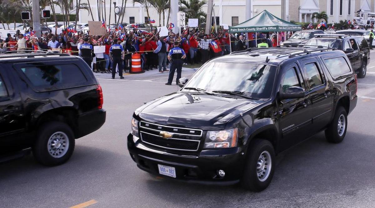 President Donald Trump is whisked quickly by the Southern Boulevard bridge in West Palm Beach Jan. 15, 2018, on Martin Luther King Day as Haitian community members showed up in force to protest reports of Trump’s recent disparaging remarks against Haiti.