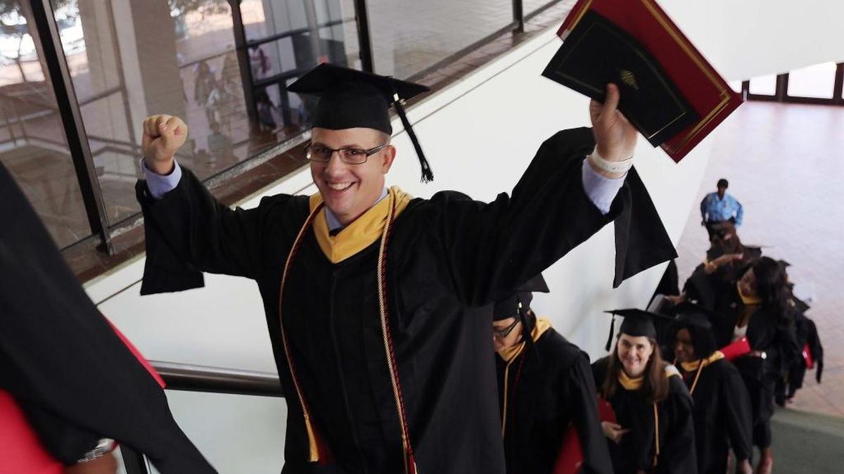 Joel Breneman, center, walks up a stairwell during a Barry University graduation at the James L. Knight Convention Center on Saturday, May 6, 2017. Breneman graduated from the School of Social Work, defying all odds after undergoing several heart surgeries during his time at Barry; two of them in this last semester.