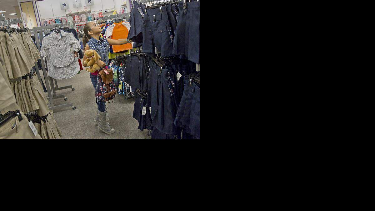 
UNIFORM FASHION: Lauren Seda 9, a student at Jack D. Gordon Elementary School, looks for her uniform size at the JC Penney store in the Dadeland Mall. A House panel on Thursday approved a bill that would encourage school districts to adopt a standard attire policy for students in grades K-8.
