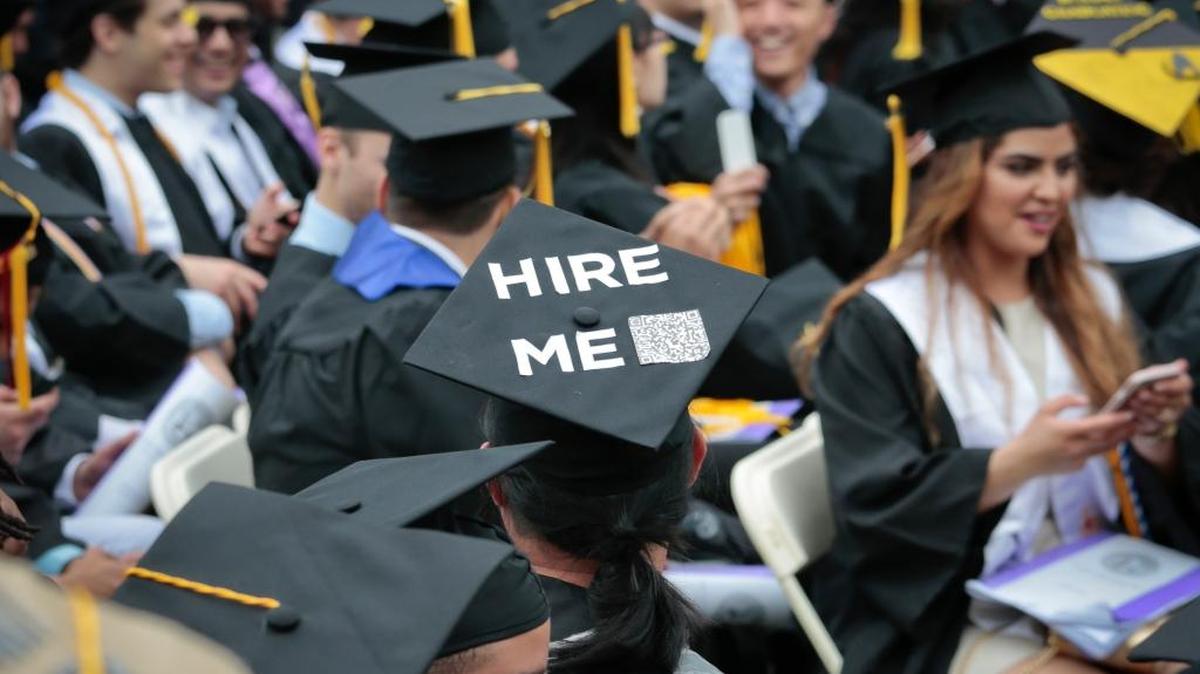 A graduating student wears a cap reading "hire me," as the City College of New York (CCNY) class of 2016 assemble for commencement, Friday June 3, 2016, in New York.