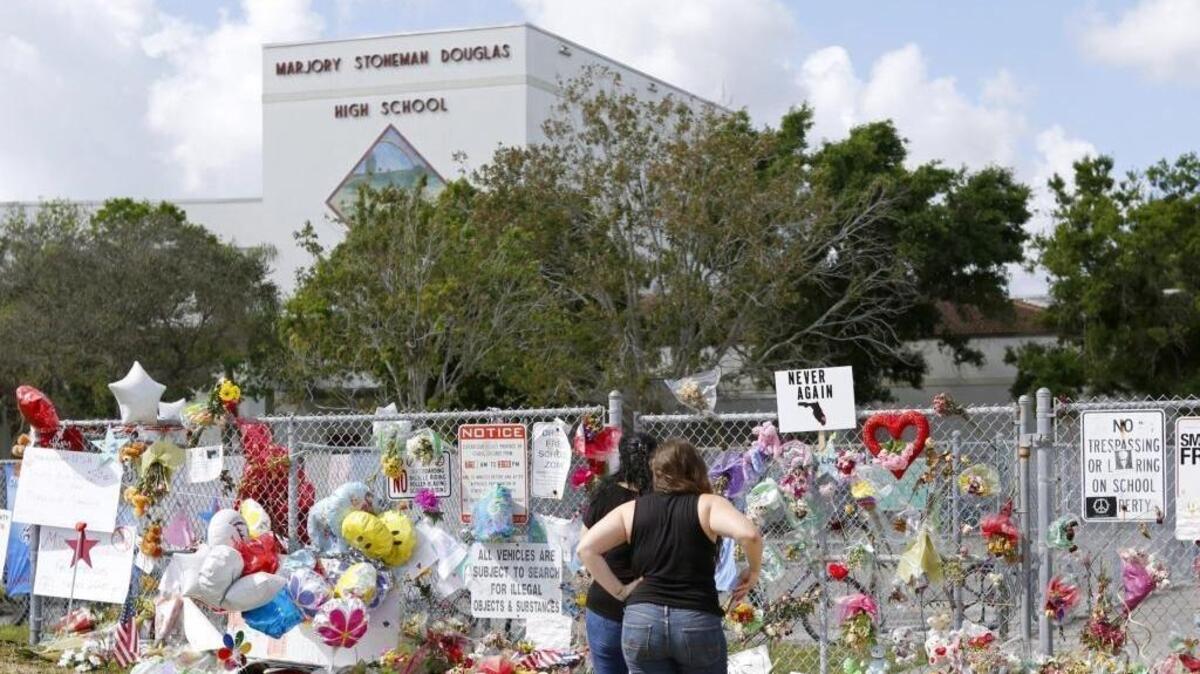 Mourners paid tribute at a memorial at Marjory Stoneman Douglas High School on Sunday, Feb. 25, 2018, during an open house that allowed parents and students to return to the school for the first time after 17 people were killed in a mass shooting at the Parkland school on Feb. 14.