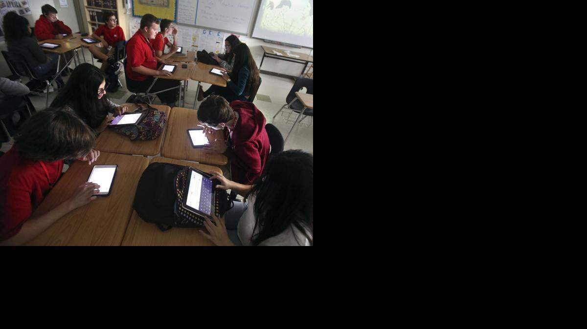 
Miami Beach Senior High ninth graders work by the glow of electronic tablets in Nadia Zananiri's World History class on Friday, Nov. 7, 2014. 
