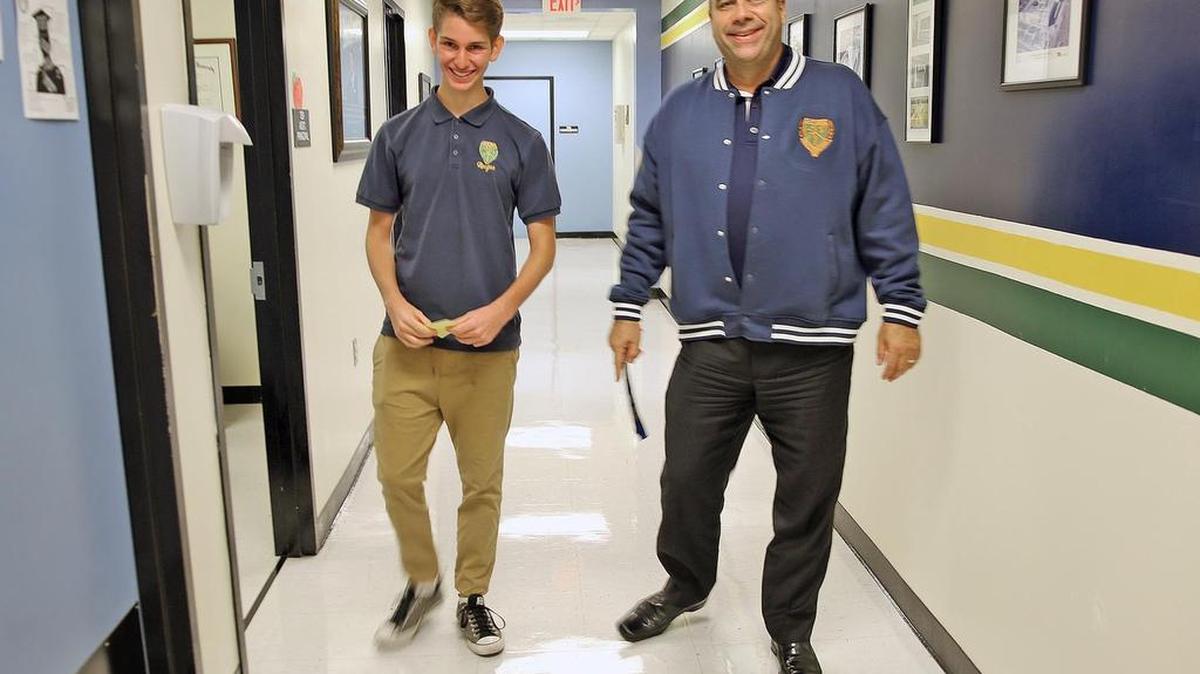 Friday, August 25, 2017- Ronald W. Reagan Doral High School principal Juan Carlos Bouè, right, walks down the hallway with Antonio Bonaduce, an 18-year-old recent arrival from Venezuela.