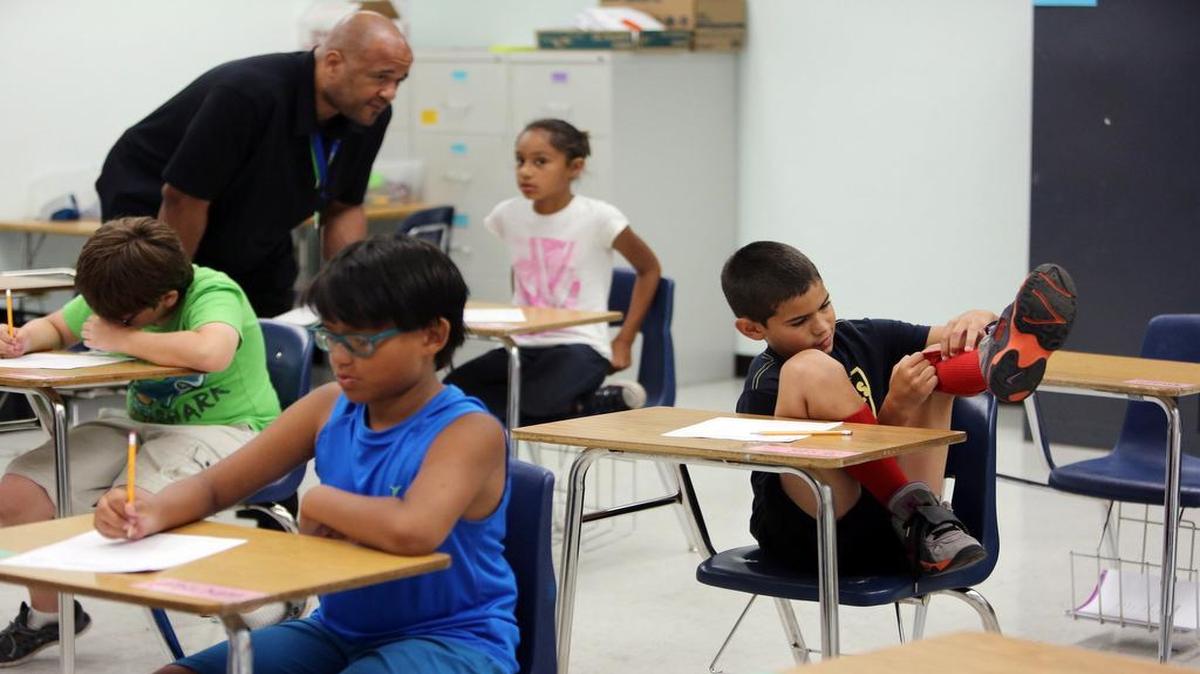 Teacher Herbert McArthur, Jr. works with Samantha N. as Jesus G. gets a little distracted from his studies during a summer program for children with ADHD run by Florida International University. FIU’s Center for Children and Families has been working with Miami-Dade County Public Schools to come up with the best ways to accommodate students with ADHD in the classroom.