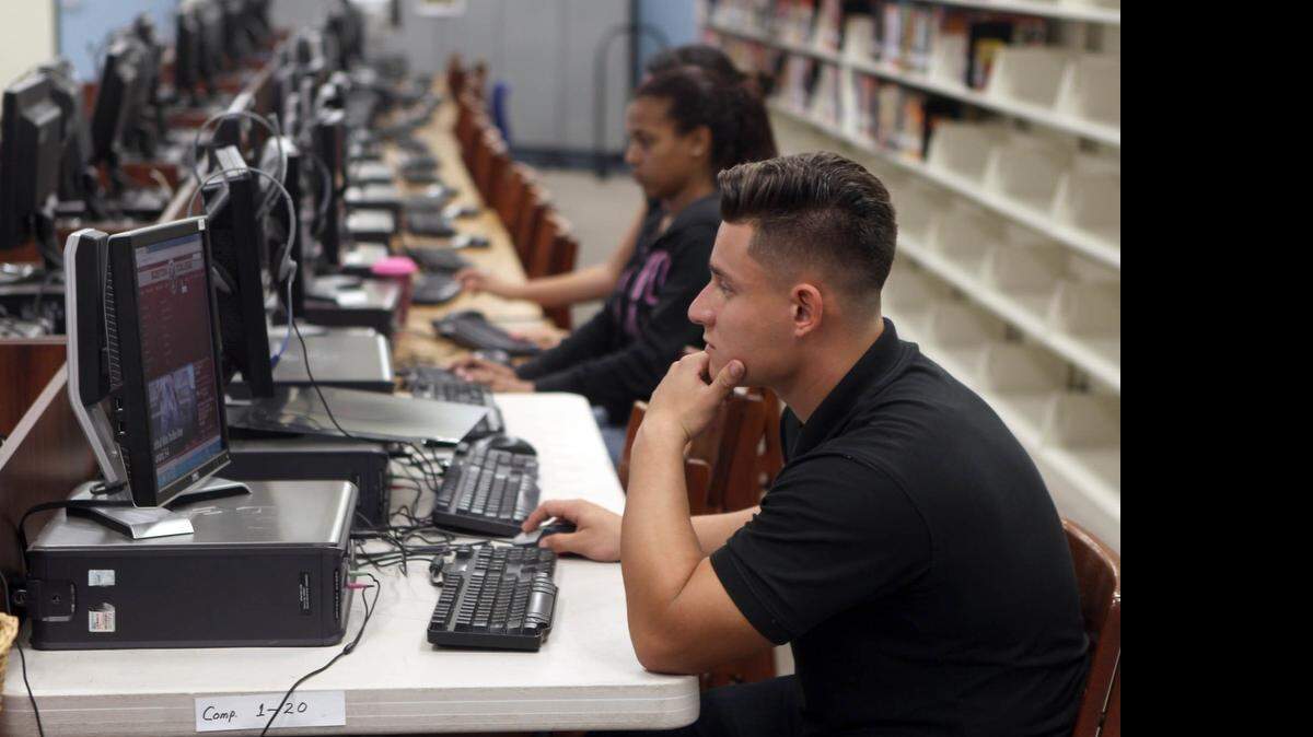 
Jesse Rascon, center in black shirt, a senior in the IB program at John Ferguson High in Kendall, being photographed at the school, Friday, April 17, 2015. He is one of 3,100 students that UF offered admission through its new PaCE, a program where students must earn at least 60 credits – the equivalent of two years – online before being allowed to enroll as traditional UF students.


