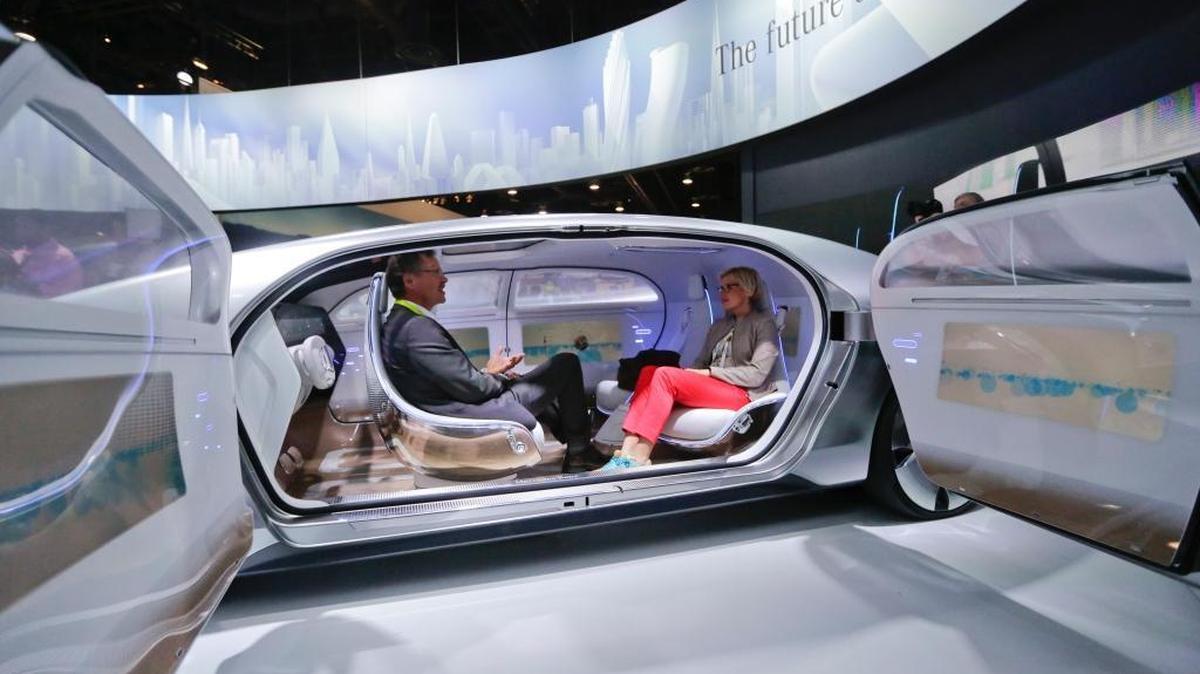 In this January 2015 file photo, attendees sit in the self-driving Mercedes-Benz F 015 concept car at the Mercedes-Benz booth at the International CES, in Las Vegas.