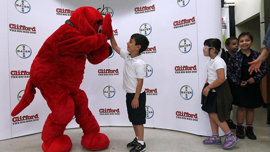Clifford the Big Red Dog high-fives a student at Coral Park Elementary as Bayer Animal Health partnered with the iconic character to create limited-edition copies of ‘Clifford Goes to the Doctor.’