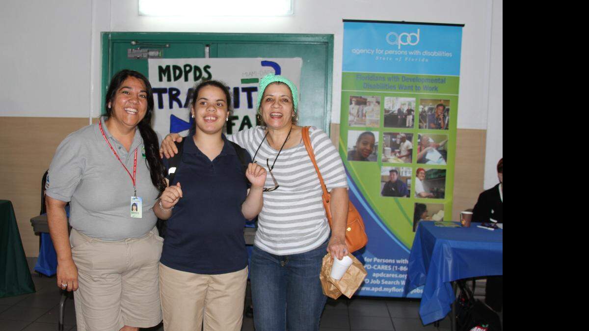 
Arlene Bouza-Jou, left, who runs a sports program for children with autism for Miami-Dade County's Parks, stands with mother and daughter, Verenita Mejia, right, and Beatrice Mejia, center, at the Transition Resource Fair in southwest Miami, which helps place special-needs adults into programs that help them continue learning after they ‘age out’ of school.
