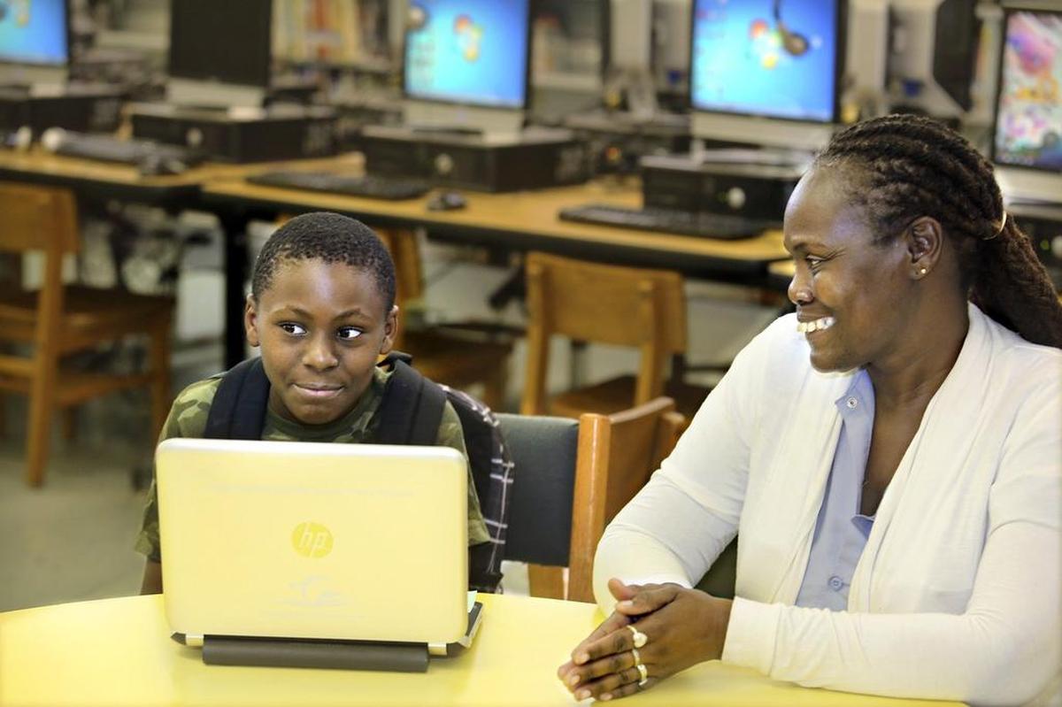 In the media center at Liberty City Elementary School, Christian Fussell, 11, a rising fifth-grader, and his grandmother Phyllis Richburg talk about how Christian benefited from having the school-issued laptop at home last school year. 