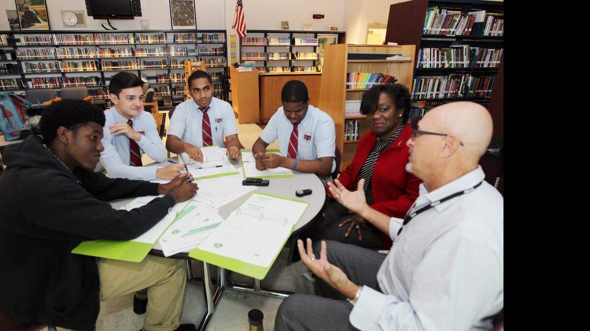 
From left, students Richard Bethel, 17, Sebastian Lorenzo, 15, Edgar Otero,17, and Juan Brown, 17, with Priscilla Dames, Wingspan Seminar president and founder, and Norby Rudel, program coordinator for the Rotary Club of Miami's annual peace conference, during a training session to implement a peer mediation program at the Young Men's Preparatory Academy in Miami on Thursday, April 23, 2015.

