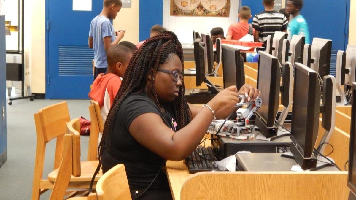 Eighth grader Senai Miller putting the final touches on her robot at CodeMasters Summer Math & Robotics Camp Showcase on July 27.