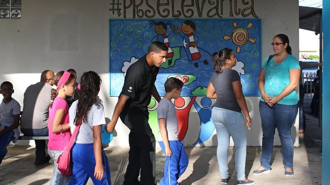 Parents and students walk into the Julio Selles Sola Elementary School in Rio Piedras, a neighborhood of San Juan, Puerto Rico, on Tuesday, October 24, 2017.