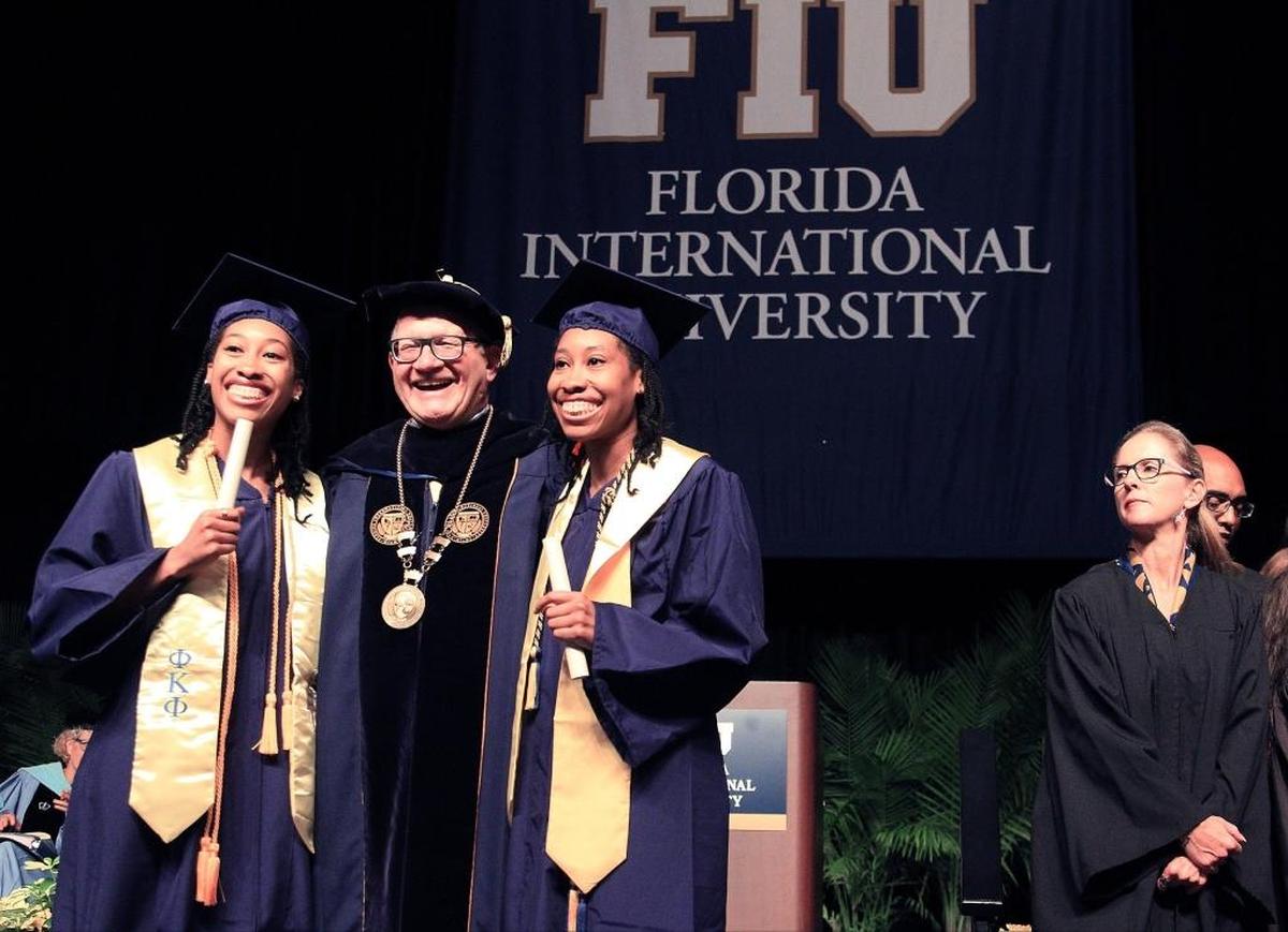 Shonda and Shalisha Witherspoon, identical twins who graduated from FIU with degrees in Information Technology and the highest GPA (3.95) in the College of Engineering and Computer Science, stand with Dr. Mark B. Rosenberg, president of FIU, after receiving their diplomas, May 9, 2016.