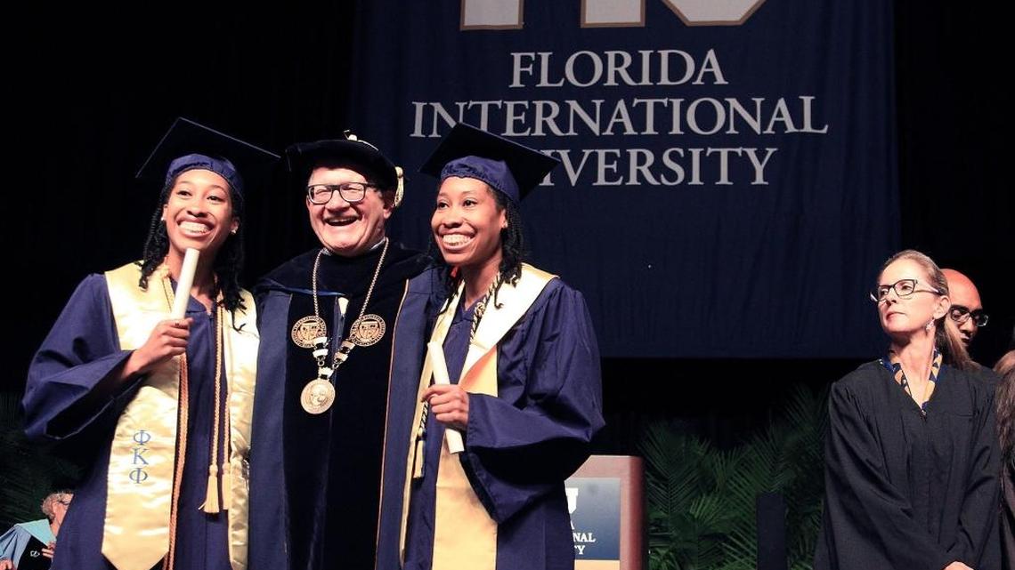 Shonda and Shalisha Witherspoon, identical twins who graduated from FIU with degrees in Information Technology and the highest GPA (3.95) in the College of Engineering and Computer Science, stand with Dr. Mark B. Rosenberg, president of FIU, after receiving their diplomas, May 9, 2016.