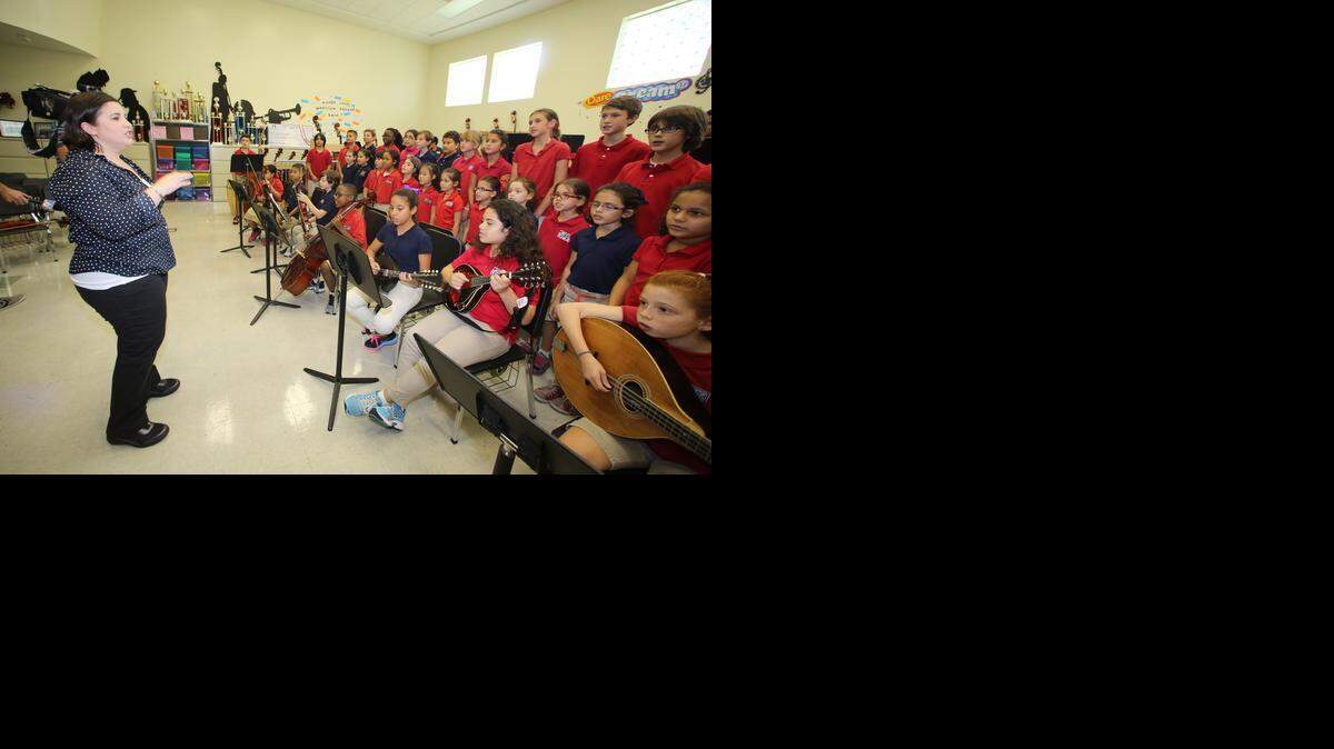 
South Miami K-8 school teacher Vivian Gonzalez directs some of the students in her music class after a visit from the group Lady Antebellum on Monday.


