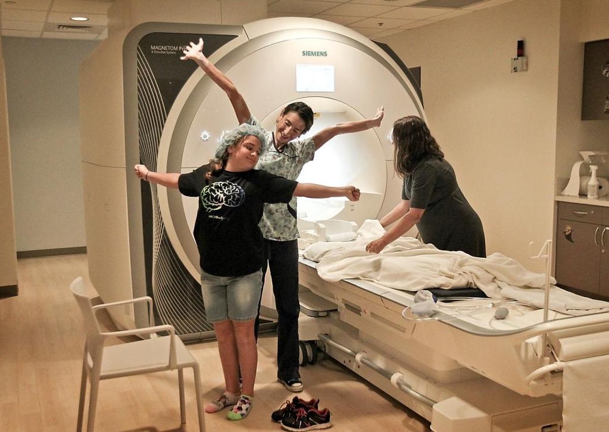 Professor Angie Laird, director of the Center for Imaging Studies (at right) and MRI Technologist Andrea Roman get 10 year-old Sara Castro to stretch after she comes out of the MRI machine at Florida International University earlier this month. FIU is taking part of a nationwide 10-year study involving brain scans of children. About 700 Miami-Dade County kids are involved.