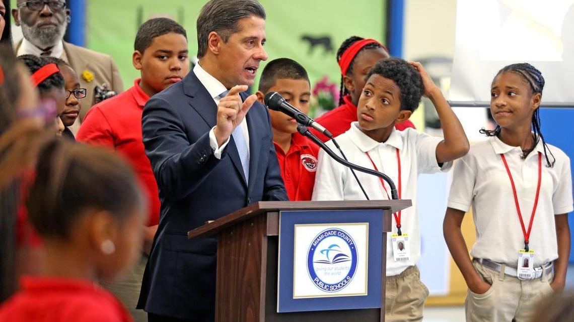 
Miami-Dade Schools Superintendent Alberto Carvalho talks about the iAttend program as Jose de Diego Middle School 6th grader Jaylin Terzado scratches his head and listens at a press conference at the school, September 18, 2015. 
