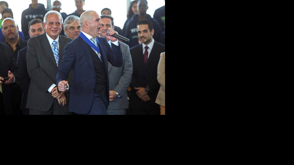
Rapper Pitbull pumps up the crowd at the Sports Leadership and Management Academy in Little Havana as officials, including Miami Mayor Tomás Regalado, look on.
