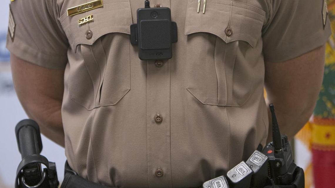 A Miami-Dade Police officer shows off a body camera during a press conference last year. Now Miami-Dade schools police could be outfitted with them as well.