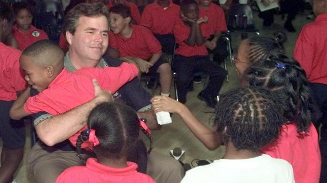 Former Gov. Jeb Bush gets a hug from a student at Liberty City Charter School. Bush helped open the school, which closed in 2008 after receiving more than $1 million from the state in capital funding.