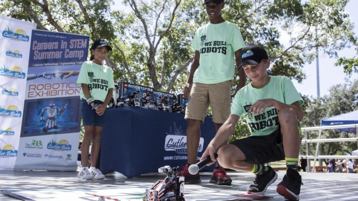 From left, Lily Hiraldo, Kionne McKhee and Connor Callaham show off their robot Bobby during a STEM Summer Camp presentation at Cutler Ridge Park on Saturday, Aug. 12, 2017.