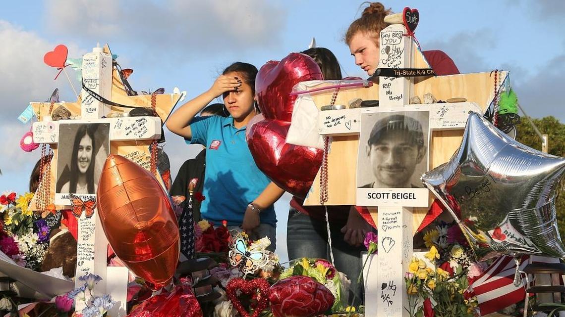 Luisa Sorroza and Corey Rottman, students at Atlantic Technical College, pay tribute at a memorial for the victims of the shooting at Marjory Stoneman Douglas High School in Parkland, on Wednesday, Feb. 21, 2018.