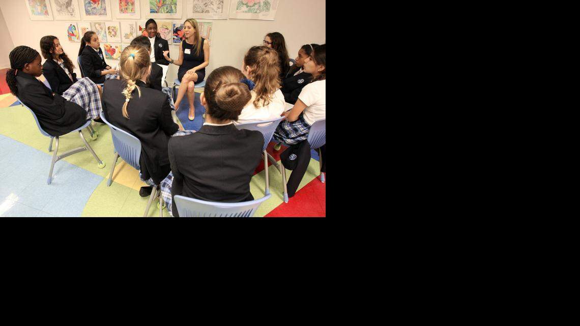 
Real estate attorney Karyl Argamasilla, center, shares her insights and goals with students in the hallway of Young Women's Preparatory Academy. On Wednesday, March 18, teachers at Young Women's Preparatory Academy located in Little Havana traded places with top female executives in Miami, who spoke to classrooms of young women about the challenges and triumphs in their careers and introduce them to future job opportunities in fields like banking, law, real estate, law enforcement and construction.
