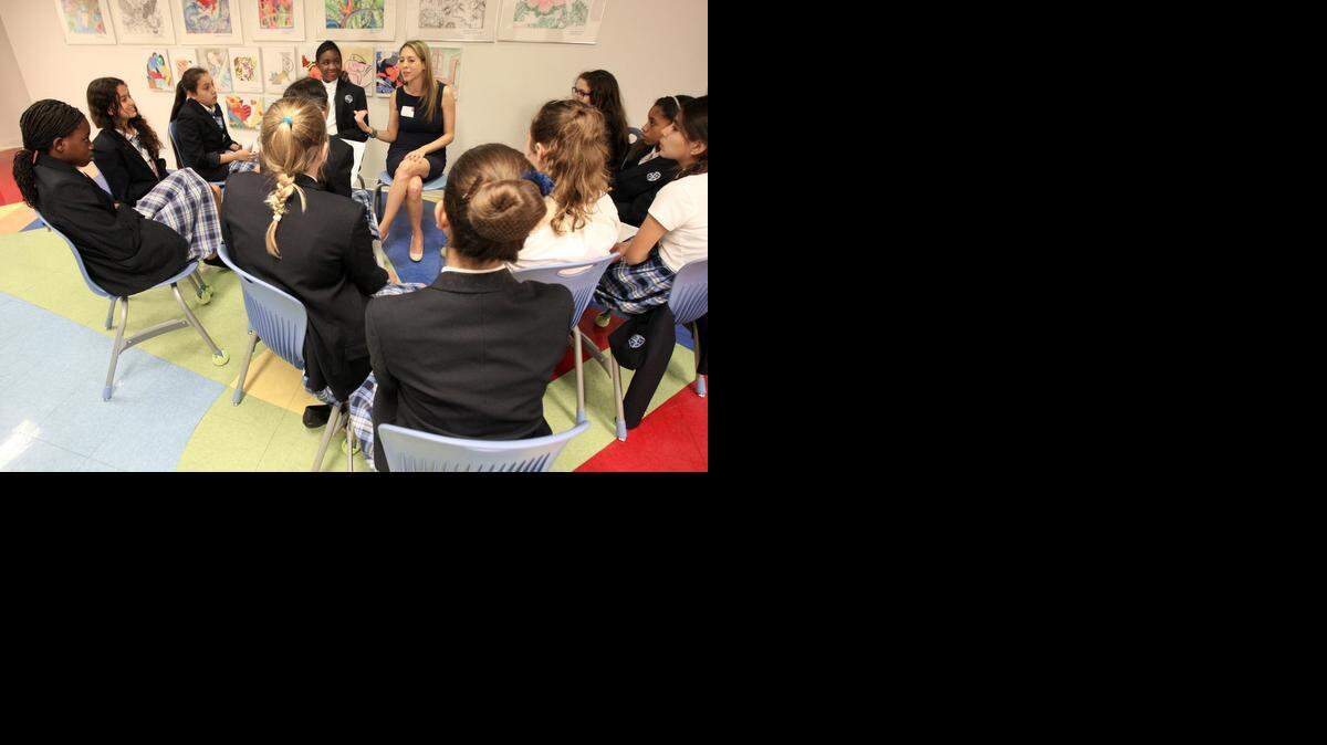
Real estate attorney Karyl Argamasilla, center, shares her insights and goals with students in the hallway of Young Women's Preparatory Academy. On Wednesday, March 18, teachers at Young Women's Preparatory Academy located in Little Havana traded places with top female executives in Miami, who spoke to classrooms of young women about the challenges and triumphs in their careers and introduce them to future job opportunities in fields like banking, law, real estate, law enforcement and construction.
