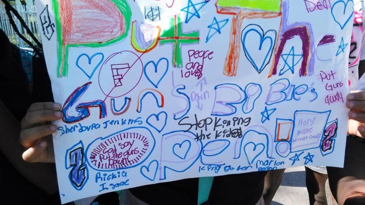 One sign put together by elementary school children protesting gun violence where the live in the Liberty Square housing project.