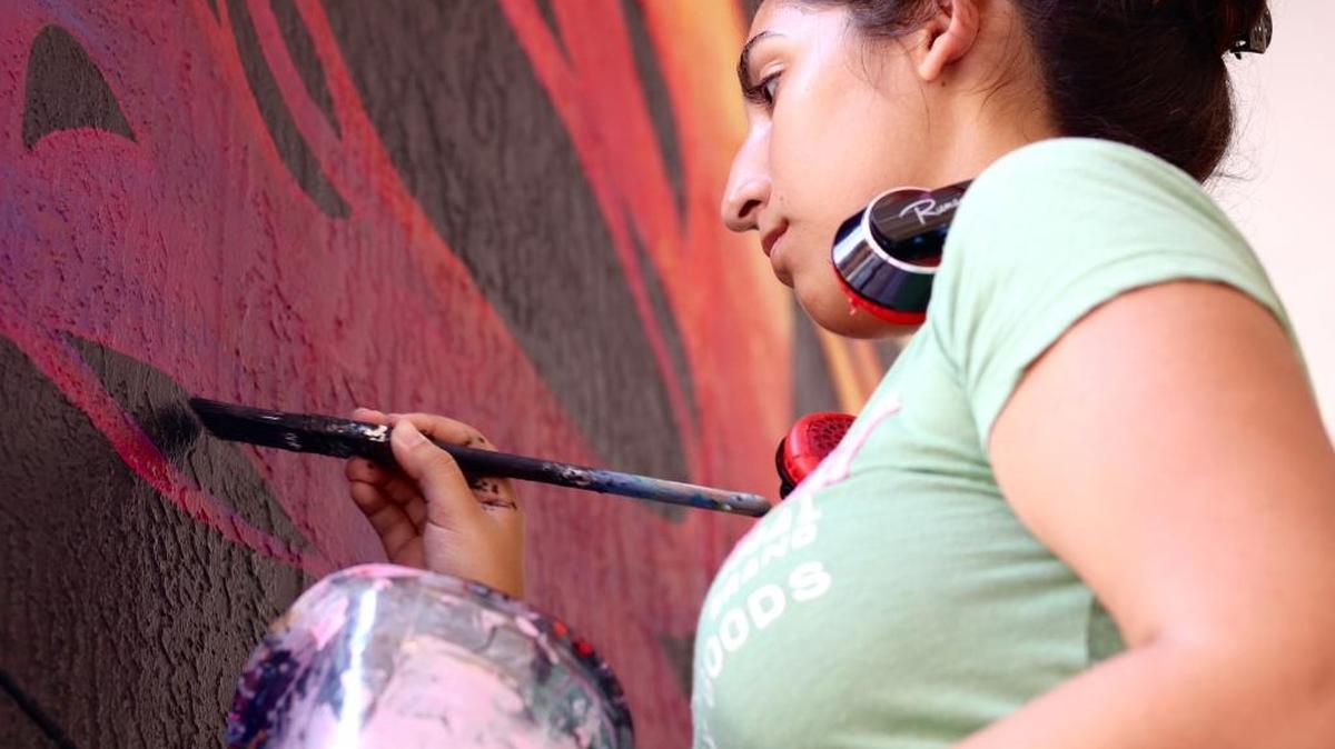 Amanda Muñoz, 18, paints a column at the Shops at Sunset Place in South Miami.