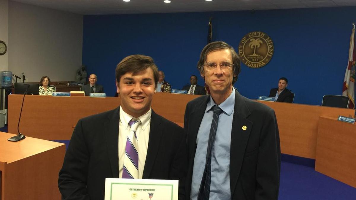 
Eddie Pozo of Christopher Columbus High School stands with South Miami Mayor Philip Stoddard after being awarded during a recent commission meeting. 
