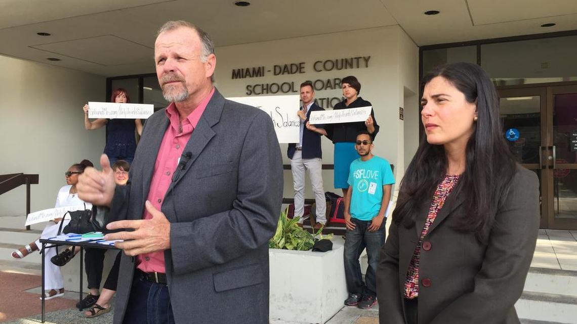 Shawn Beightol and Thais Alvarez join other teachers in front of the Miami-Dade County School Board building to announce their intent to sue over pay issues.