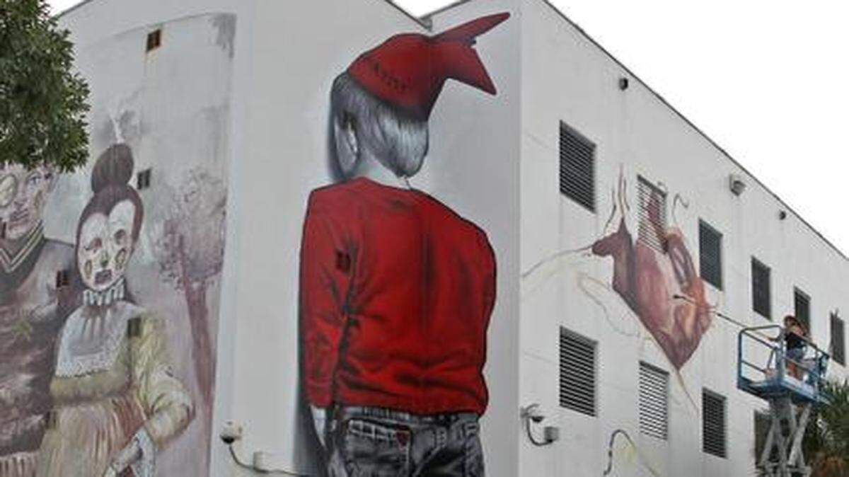 
Students from the Jose de Diego Middle School, at 3100 NW 5 Ave. in Wynwood, gaze at the artwork going up on the outside of their building. 
