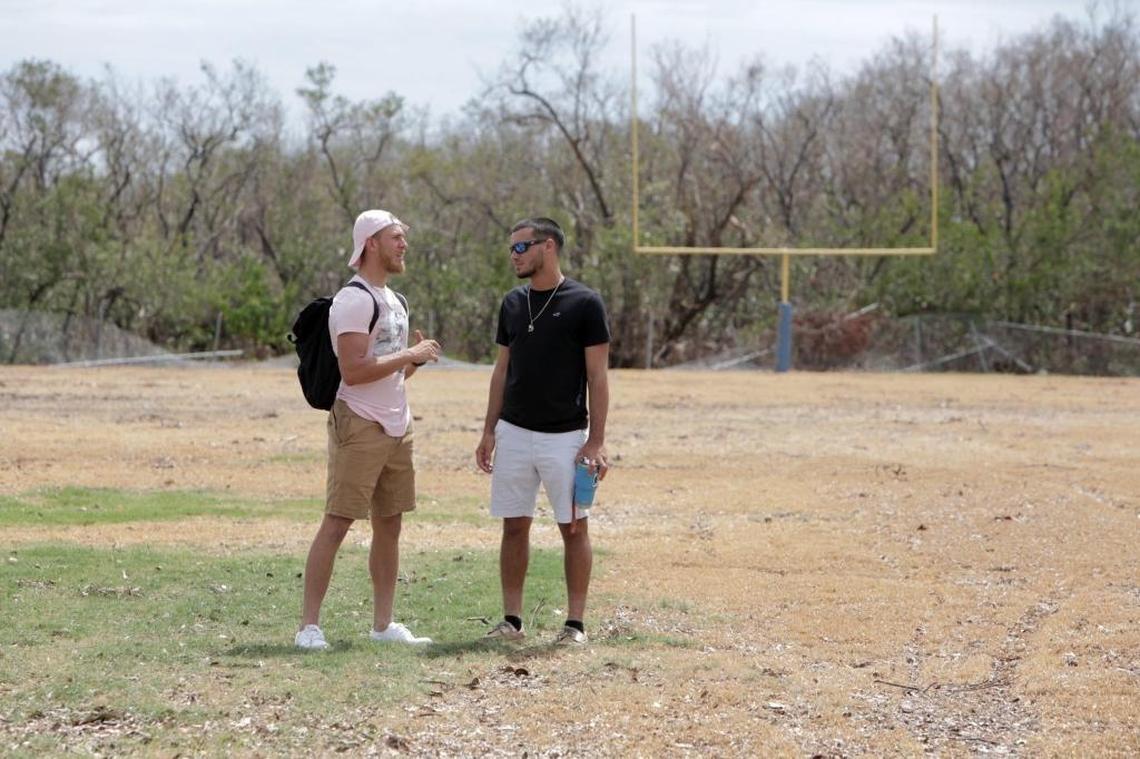 High School Seniors Esteban Sainz, 18, and Randy Culmer, 17, stand on the destroyed football field at Marathon Middle and High School.