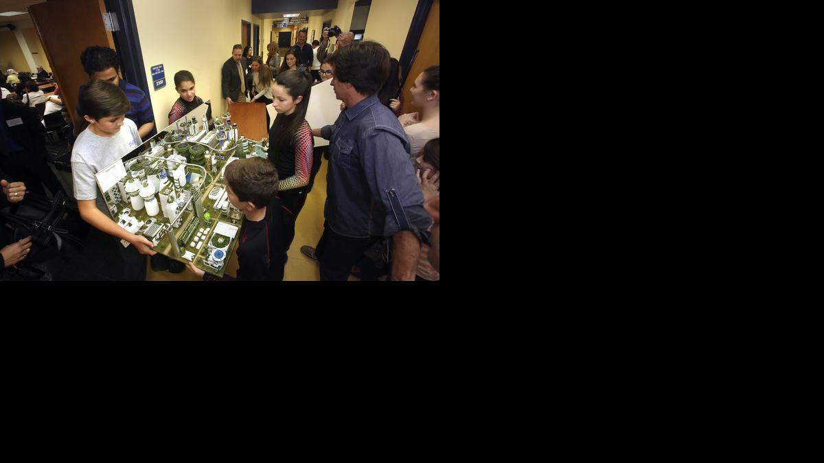 
St. Thomas the Apostle Catholic School seventh-graders Rafael de la Torre, left, Sophia Corrales, center, and Brooke Filliben, right, help carry their "Future Cities" project entry into the judging room on Saturday, Jan. 17, 2015 at the Florida International University Engineering Center in Miami. The South Miami school's team came in second in the South Florida Region arm of the national engineering competition for middle schoolers. Projects were designed for the theme "Feeding Future Cities." The challenge: to design a city that can sustain life for at least one growing season with a budget of $100. The first-place winners from each qualifying regional competition can compete in the Future City Competition National Finals in Washington, D.C., Feb. 15-18, 2015 in preparation of Engineers Week.
