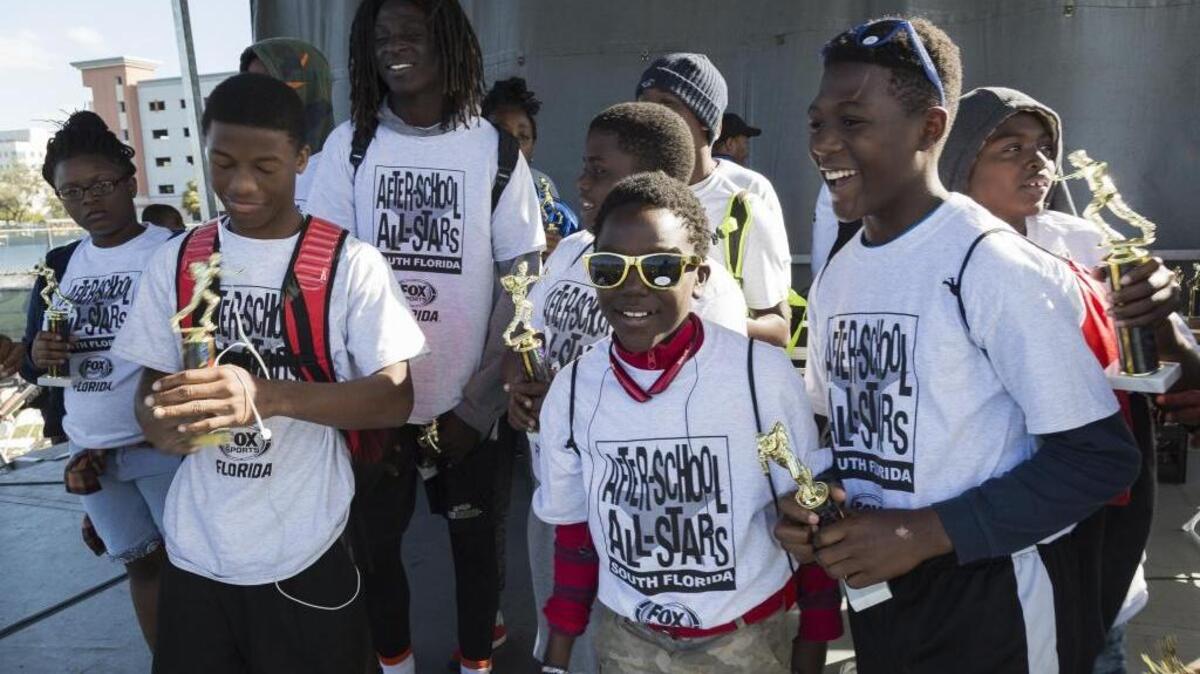 Students from Brownsville Middle School receive first-place flag football trophies during the awards ceremony at SuperFest on Saturday at Florida International University’s Modesto Maidique Campus.