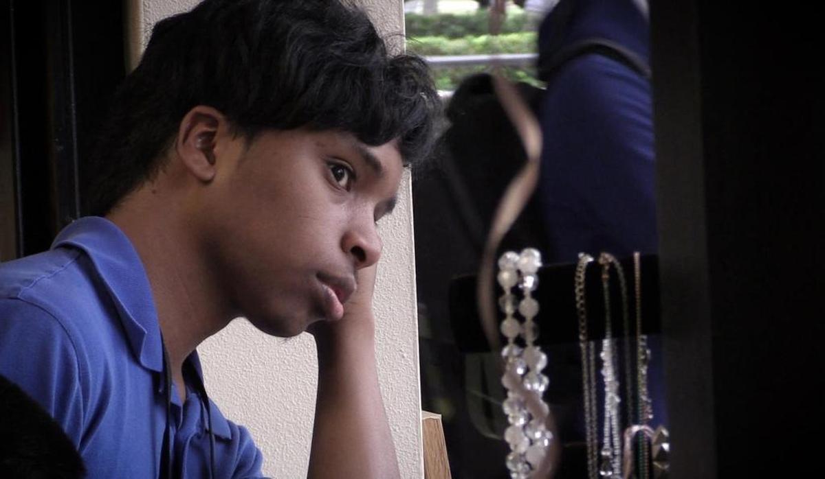 Danny Vaca-Figuereo, 19, looks out the window of the Falcon Gift Shop at John A. Ferguson Senior High during the lunchtime rush.
