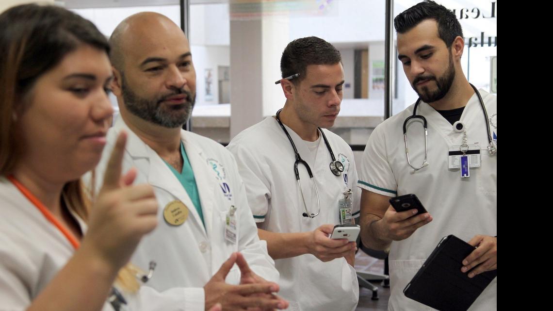 
Andres Caiaffa, a professor at Miami Dade College’s Benjamin Leon School of Medicine, allows students to use tablets and smartphones as part of the classroom experience at the Simulation Lab. From left, Cassandra Gonzalez, Andres Caiaffa, Alex Escoto and Enrique Gil.
